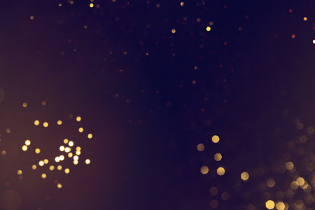 Golden abstract bokeh on black background. Celebrating Christmas, New Year or other holidays.の写真素材