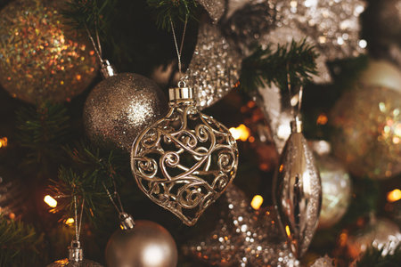 Silver Christmas decorations on a fir branch. The image is in soft focus.の写真素材