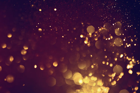 Golden abstract bokeh on black background. Celebrating Christmas, New Year or other holidays.の写真素材