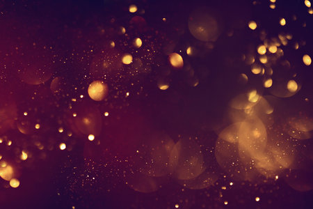 Golden abstract bokeh on black background. Celebrating Christmas, New Year or other holidays.の写真素材