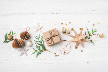 Festive Christmas background with gift box and Christmas decorations on white wooden table. Top view.の写真素材