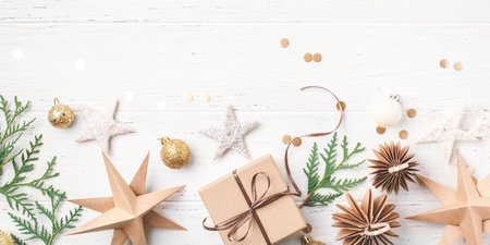 Festive Christmas background with gift box and Christmas decorations on white wooden table. Top view. Copy space for text.の写真素材