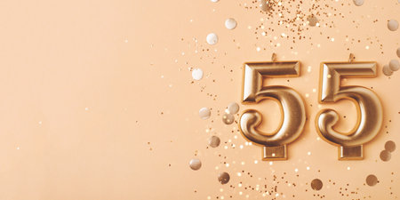 55 years celebration. Greeting banner. Gold candles in the form of number forty five on peach background with confetti.の写真素材