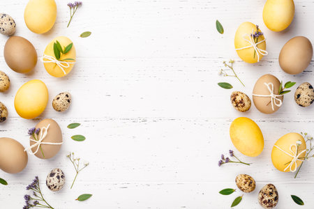 Festive Easter background. Easter eggs with flowers on a white table. Flat lay, place for text.の写真素材