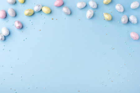Festive Easter background. Multicolored Easter eggs on a blue table. Banner with a place for text. Top view.の写真素材