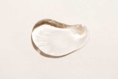 Transparent hyaluronic acid gel drop on a beige background.の写真素材