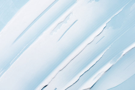 The texture of the skin or hair care product. White smear of cream, mask or balm on a blue background.の写真素材