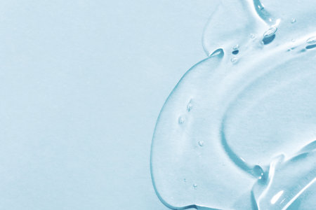 The smear of a transparent gel on a blue background. The texture of the skin or hair care product.の写真素材