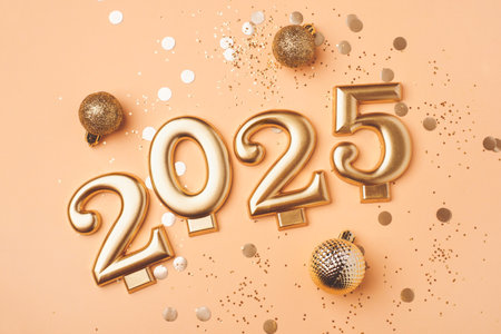Golden 2025 on a peach color background.の写真素材