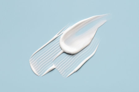 Smear of cosmetic cream on a blue background.の写真素材