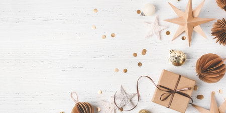 Festive Christmas background with gift box and Christmas decorations on white wooden table. Top view. Copy space for text.の写真素材