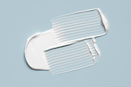 Smear of cosmetic cream on a blue background.の写真素材