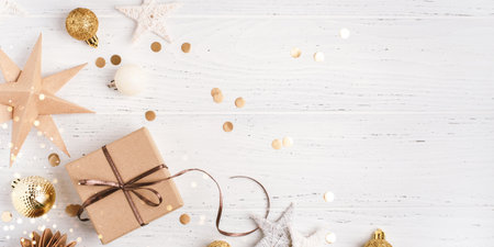 Festive Christmas background with gift box and Christmas decorations on white wooden table. Top view. Copy space for text.の写真素材