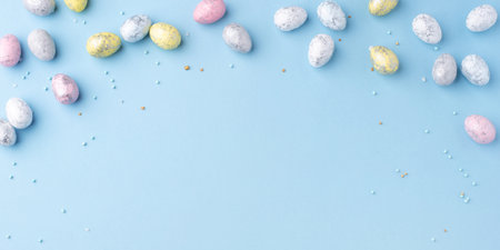 Festive Easter background. Multicolored Easter eggs on a blue table. Banner with a place for text....
