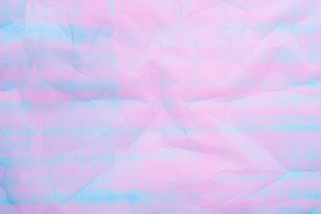 An abstract background featuring pastel hues of pink and blue with a textured crumpled paper effect.の写真素材