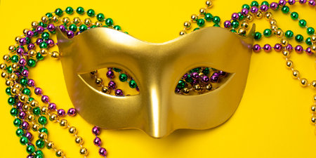 Mardi Gras beads on yellow backgroundの写真素材