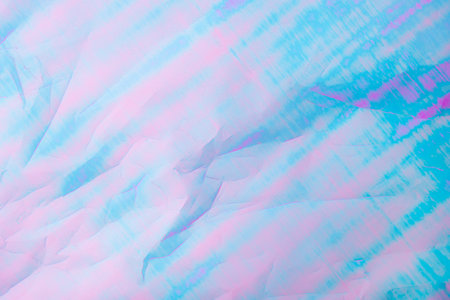 An abstract background featuring pastel hues of pink and blue with a textured crumpled paper effect.の写真素材