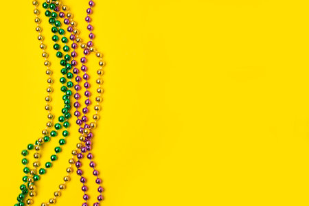 Mardi Gras beads isolated on yellow backgroundの写真素材