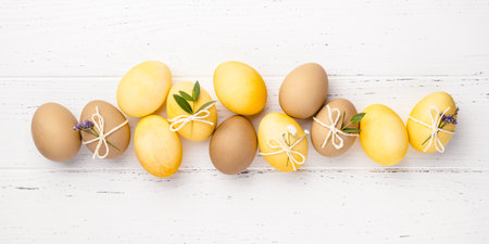 Festive Easter background. Easter eggs with flowers on a white table. Flat lay.の写真素材