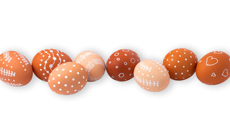 Natural brown Easter eggs with white minimalist patterns (hearts, dots, and lines)の写真素材