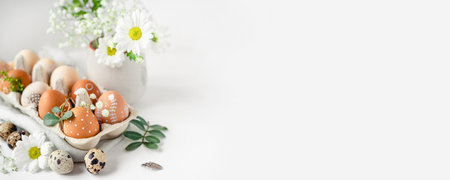 A delicate Easter background with hand-painted eggs in a box on a white table. Easter composition...