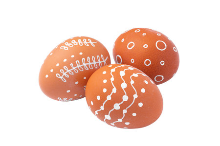 Natural brown Easter eggs with white minimalist patterns isolated on a white backgroundの写真素材