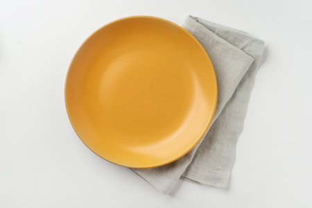 Yellow ceramic plate on a white background. Top view.の写真素材