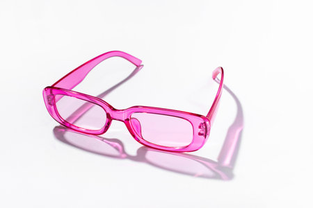 Stylish pink plastic sunglasses with transparent glass on a white backgroundの写真素材