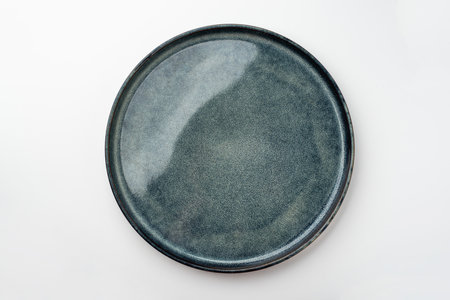 An empty textured plate on a white tableの写真素材