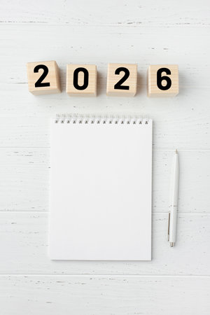Wooden cubes with numbers for the New Year 2026 with a notebook and pen