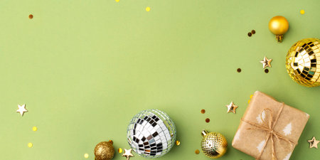 Christmas gift with gold ornaments on a green background.の写真素材