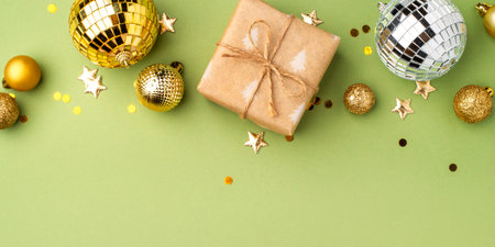 Christmas gift with gold ornaments on a green background.