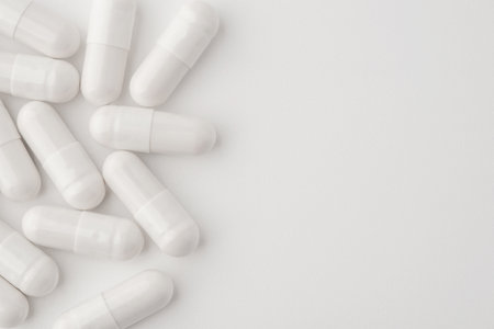 White pills on a white background. Close upの写真素材