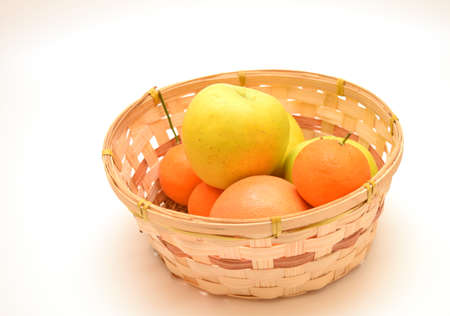grapefruitt and golden apple in woven basketの写真素材
