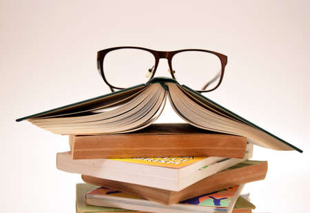 novel and poetry books and eyeglasses isolated on white background