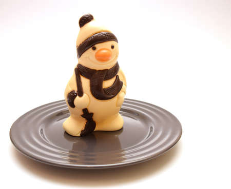 white chocolate snowman on plate isolated on white backgroundの写真素材