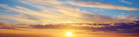 Epic sunset sky above the sea shore after the storm. Dramatic glowing colorful red clouds, natural texture, background. Fickle weather, climate change, ecology. Panoramic viewの写真素材