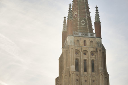Low angle view of  Church of Our Lady in a historical city center at sunset. Clear  sky  clouds. Travel guide, sightseeing theme. Belgiumの写真素材