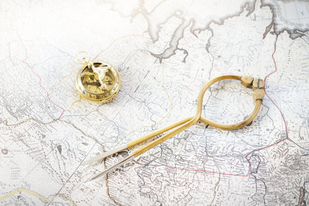 Retro styled golden compass (sundial), antique vintage W & HC 6 "brass dividers calipers nautical navigation chart tool and old white map close-up. Vintage still life. Sailing accessoriesの写真素材