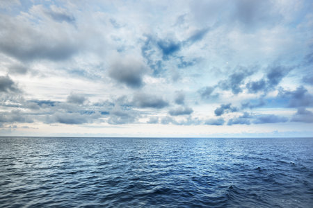 A view of the stormy North sea from a sailing boat. Cloudy blue sky reflecting in the water. Dramatic cloudscape. Rogaland region, Norway. Leisure activity, environmental conservation conceptsの写真素材