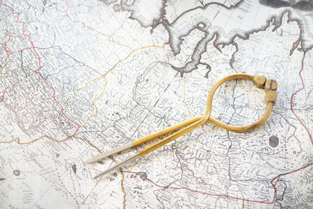 Antique W & HC 6 "brass dividers calipers nautical navigation chart tool, old white chart close-up. Vintage still life. Sailing, travel accessories. Planning, adventure, hobby, recreation, concept artの写真素材
