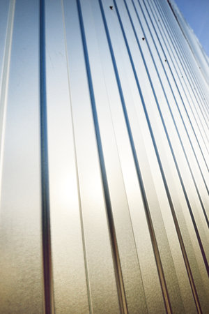 Low angle view of the silvery warehouse wall. Metal siding, texture, close-upの写真素材