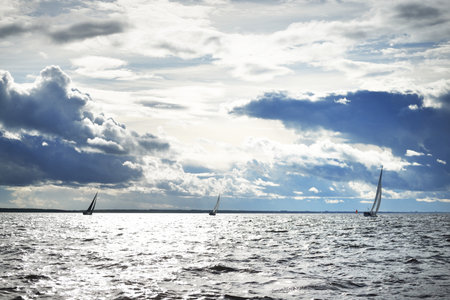 Sailing yacht regatta. Modern sailboat racing through the waves. Dramatic sky before the thunderstorm. Terrific cloudscape. North Germany, Kielの写真素材