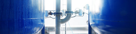 Large industrial water treatment and boiler room. Shiny steel metal pipes, blue pumps, valves....