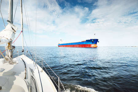 Large blue bulk carrier (cargo ship) sailing in the Baltic sea to Riga port, Latvia. A view from the...
