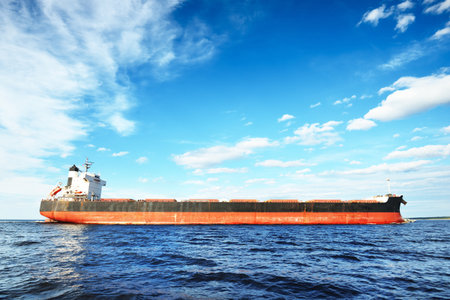Large bulk carrier (ship) sailing in the Baltic sea to Riga port, Latvia. A view from the yacht. General cargo. Global communications, logistics, industry, freight transportationの写真素材