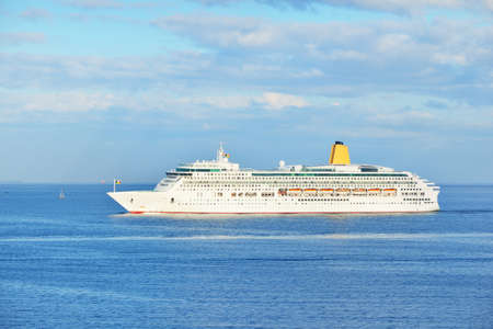 Passenger ship (cruise liner) sailing in an open sea on a clear day. Panoramic aerial view....