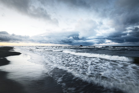 Storm clouds above the Baltic sea in winter, long exposure. Dramatic sunset sky, waves and water...