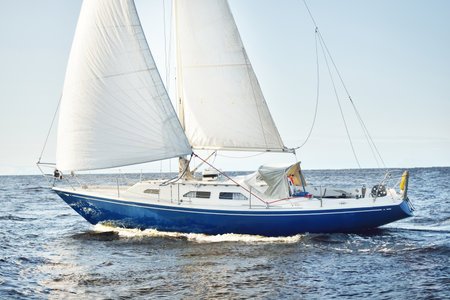 Blue sloop rigged yacht sailing in an open Baltic sea on a clear day, close-up. Riga bay, Latvia....
