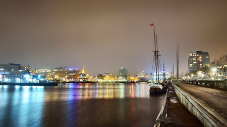 A night view of the illuminated empty promenade near the canal, no people because of the coronavirus (COVID-19) outbreak in Kiel, Germany quarantine zoneの写真素材